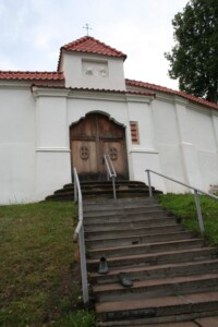 Bronzinė skulptūra „Pasivaikščiojimas palaimintojo batais“ prie Kauno seserų benediktinių vienuolyno ansamblio vadinamųjų Angelų vartų (Benediktinių g. 8). 2023 m.